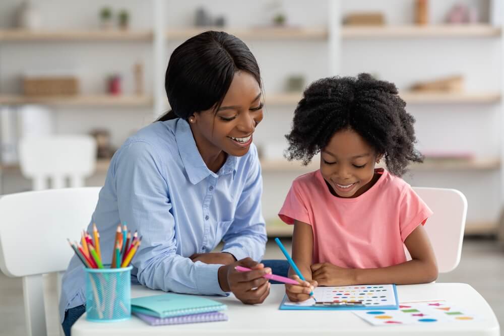 young woman psychologist working with child preschooler